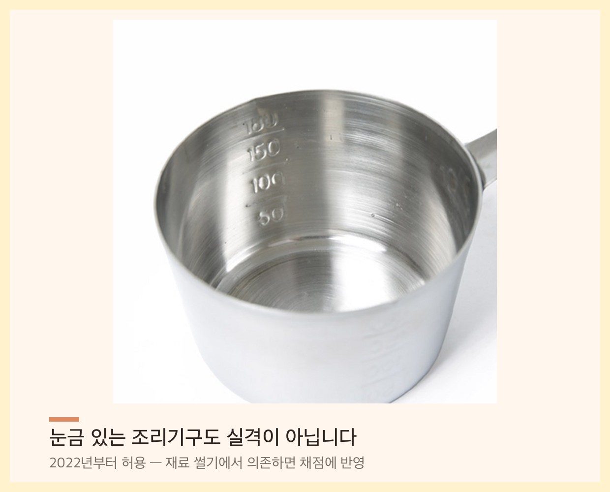눈금이 새겨진 스테인리스 계량컵 내부 — 200ml 눈금 표시